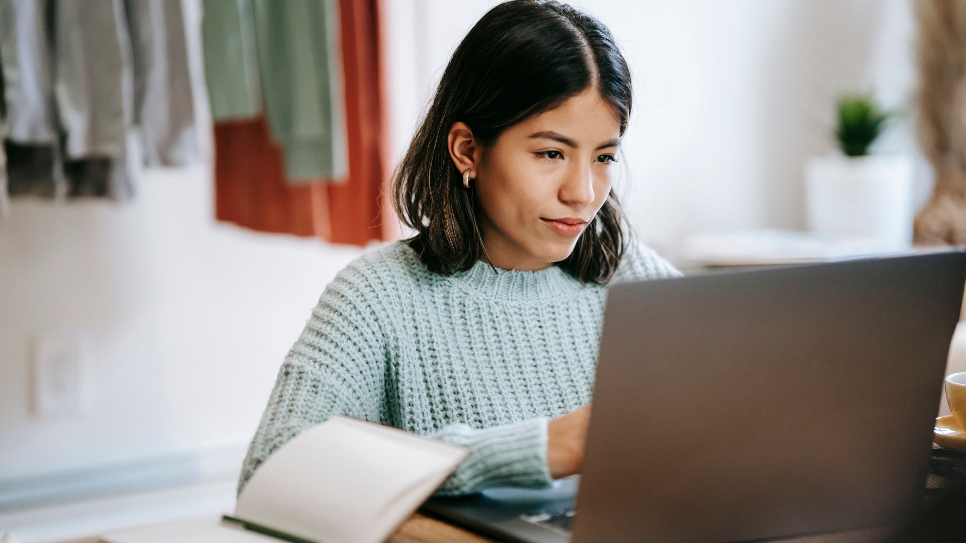 Une femme entrepreneuse concentrée devant son ordinateur, avec des post-its de planification